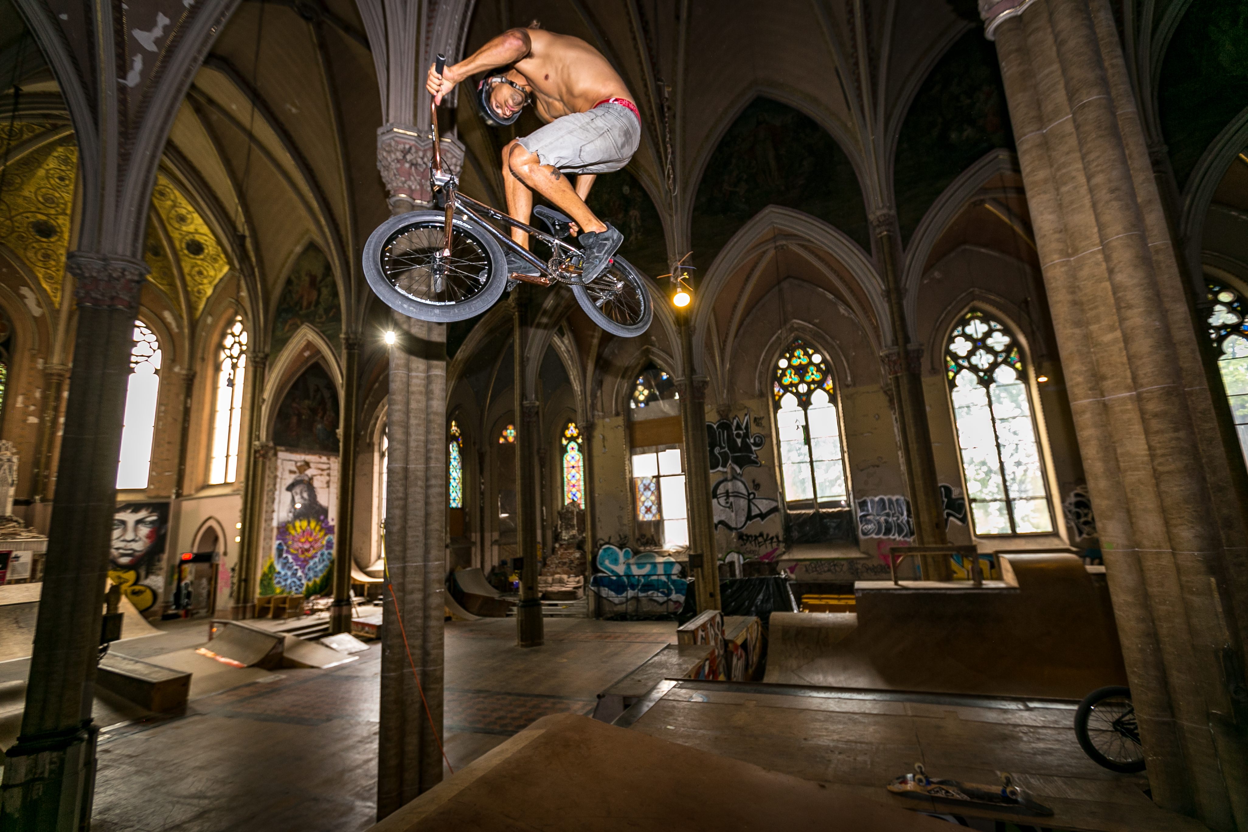 Professional BMX rider and X Games athlete Alex Landeros performs a lazy back seat grab trick in the church.